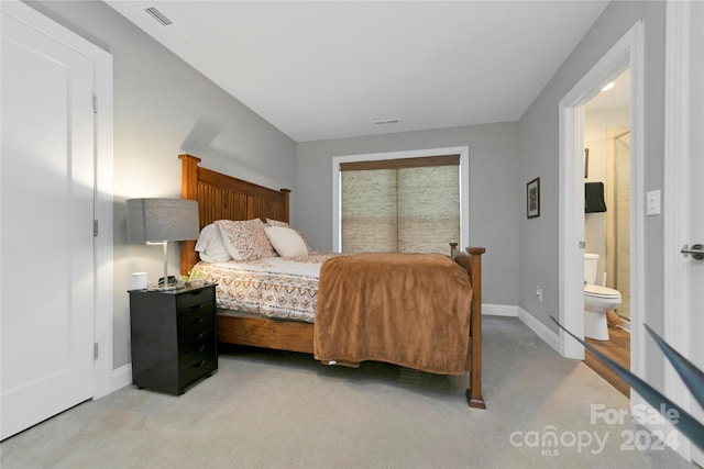 carpeted bedroom featuring ensuite bath