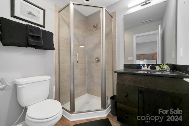 bathroom with an enclosed shower, vanity, and toilet