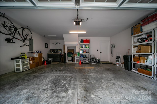 garage with a garage door opener and electric panel