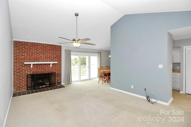 unfurnished living room with lofted ceiling, light carpet, ceiling fan, and a brick fireplace