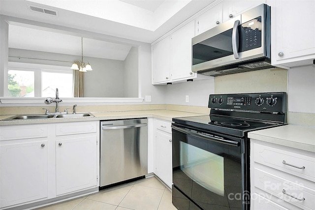 kitchen featuring a notable chandelier, stainless steel appliances, and white cabinetry