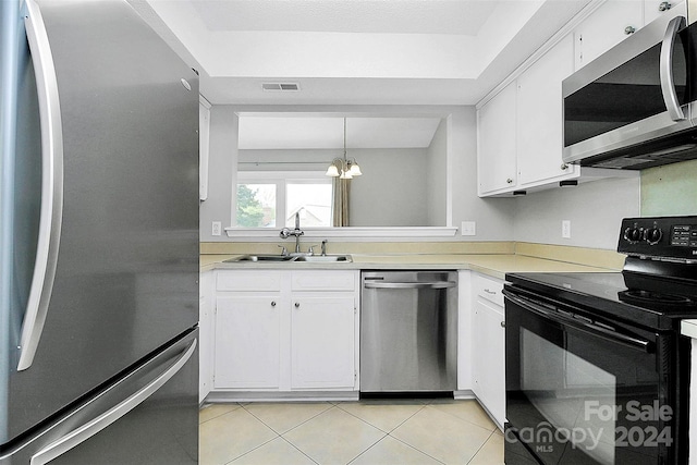 kitchen featuring white cabinetry, appliances with stainless steel finishes, hanging light fixtures, and sink