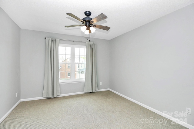 spare room featuring a textured ceiling, carpet, and ceiling fan