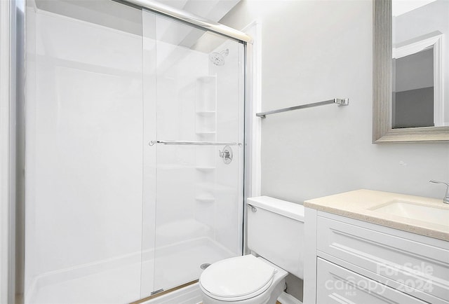 bathroom with walk in shower, vanity, and toilet