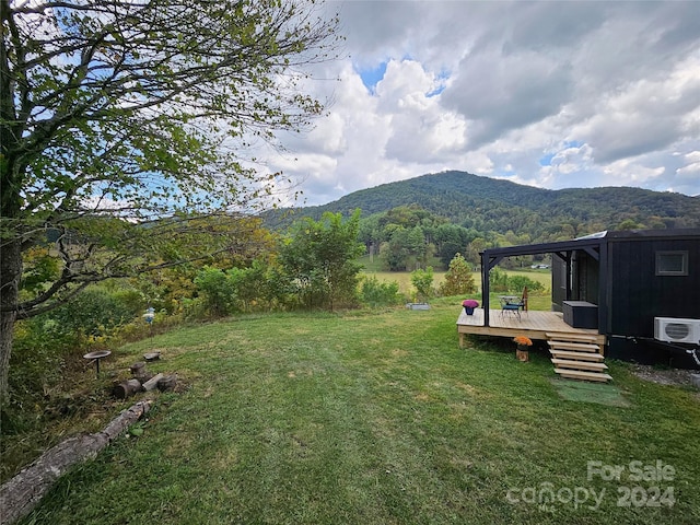 view of yard with ac unit and a deck with mountain view