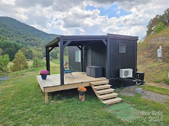 wooden deck with a lawn, a mountain view, and ac unit