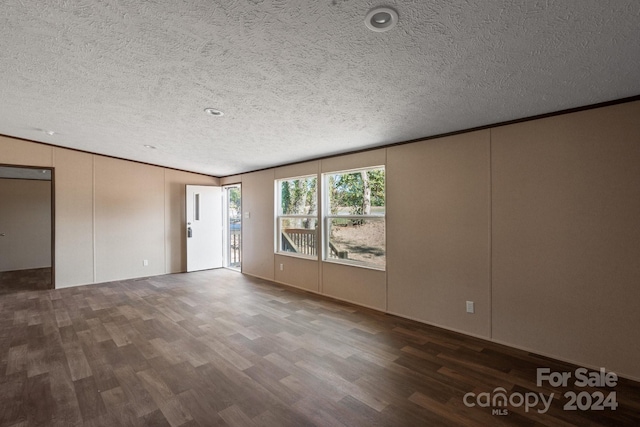 empty room featuring a textured ceiling and dark hardwood / wood-style flooring