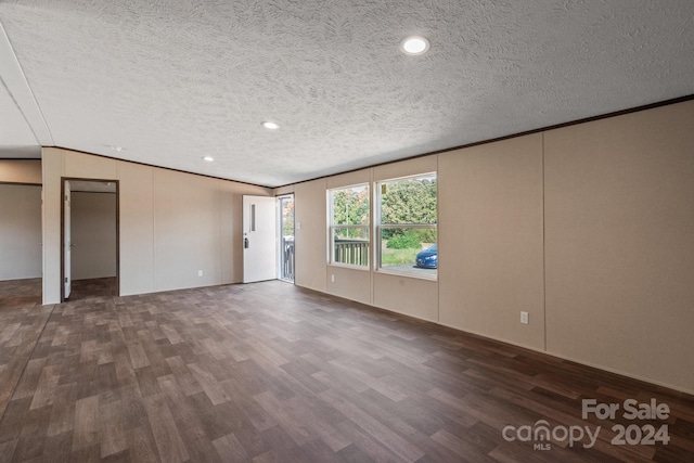 unfurnished room with dark wood-type flooring, a textured ceiling, and lofted ceiling