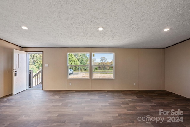 unfurnished room featuring a textured ceiling and dark hardwood / wood-style floors