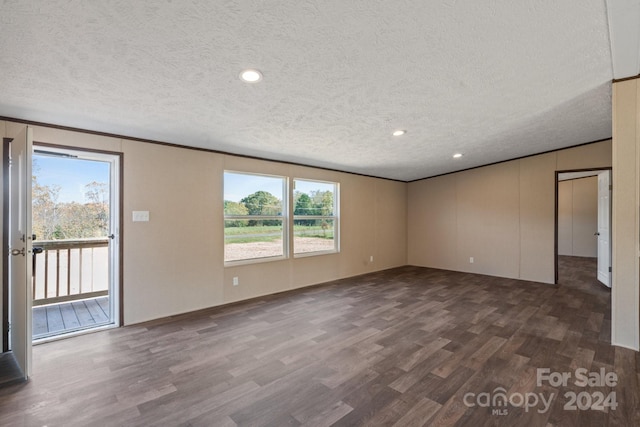 spare room with a textured ceiling and dark hardwood / wood-style flooring