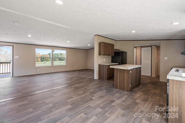 kitchen featuring dark hardwood / wood-style floors, a healthy amount of sunlight, a textured ceiling, and black fridge