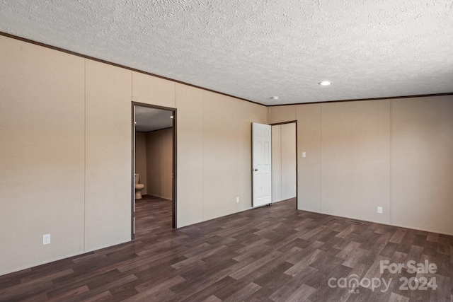 unfurnished room featuring ornamental molding, dark hardwood / wood-style floors, and a textured ceiling