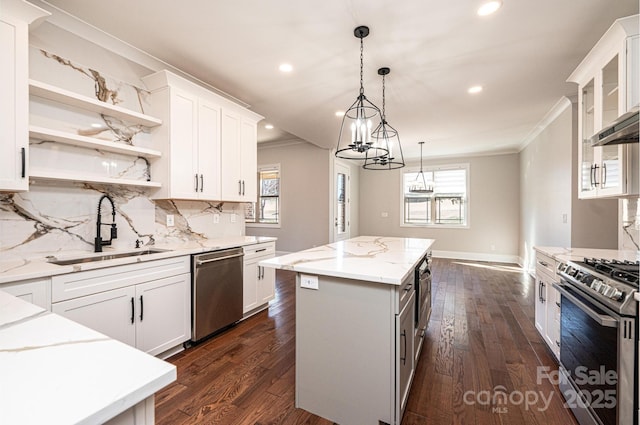 kitchen with stainless steel appliances, a kitchen island, and white cabinets