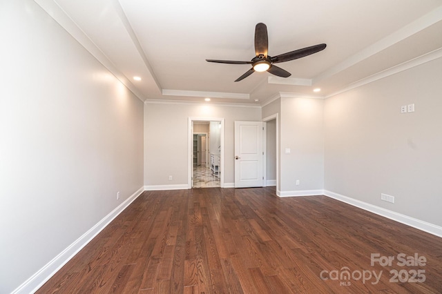 empty room with baseboards, a ceiling fan, dark wood-style floors, a tray ceiling, and recessed lighting