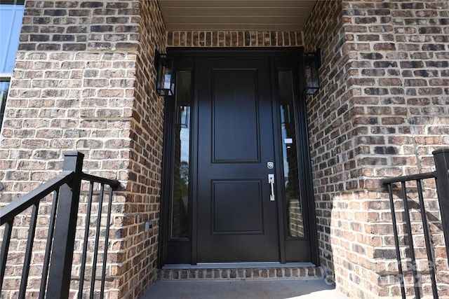 property entrance featuring brick siding