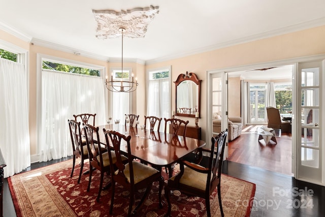 dining space featuring ornamental molding, a wealth of natural light, a chandelier, and dark wood-type flooring