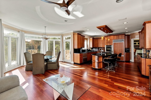 living room featuring a healthy amount of sunlight, crown molding, dark hardwood / wood-style flooring, and ceiling fan