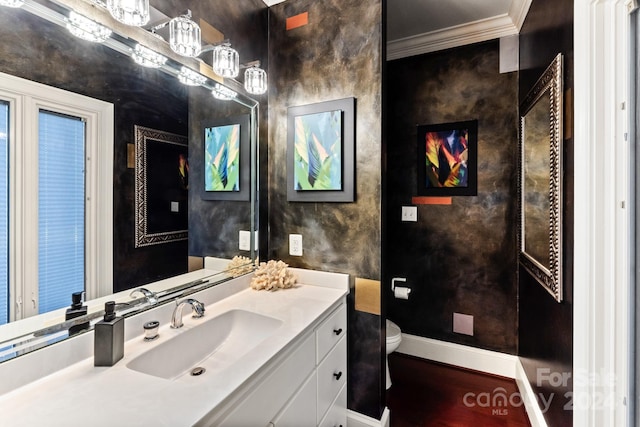 bathroom featuring hardwood / wood-style flooring, crown molding, vanity, and toilet