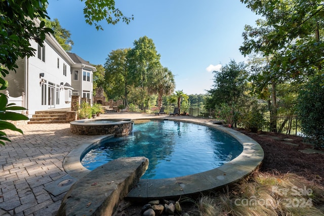 view of pool with a patio and an in ground hot tub