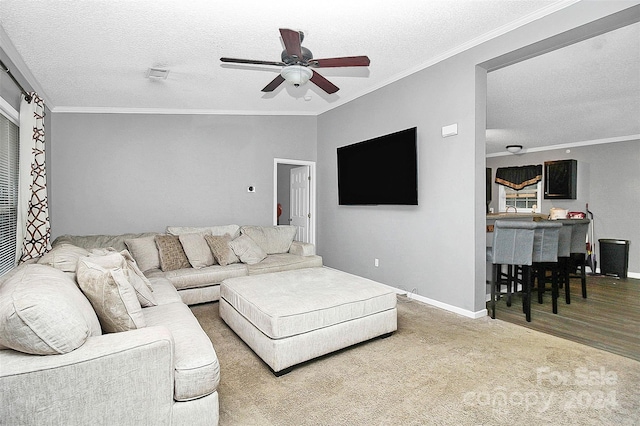 carpeted living room with ornamental molding and ceiling fan