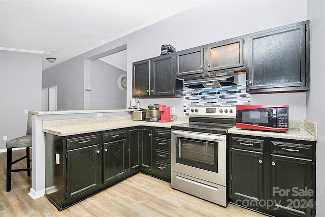 kitchen featuring kitchen peninsula, light hardwood / wood-style flooring, electric stove, crown molding, and a kitchen bar