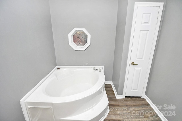 bathroom with wood-type flooring and a tub