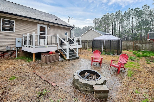 view of yard featuring a wooden deck, a gazebo, and a fire pit