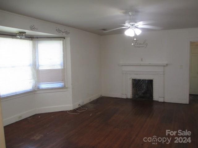 unfurnished living room with dark wood-type flooring and ceiling fan