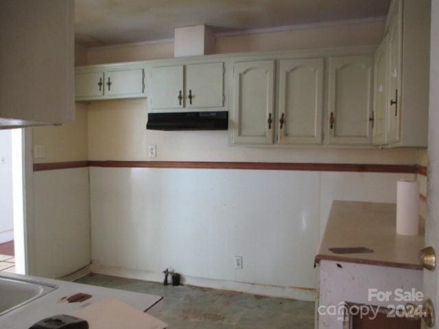 kitchen with ornamental molding and white cabinets