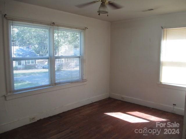 empty room with dark hardwood / wood-style flooring and ceiling fan