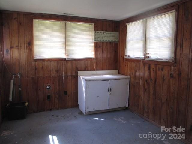 bathroom featuring wooden walls and concrete floors