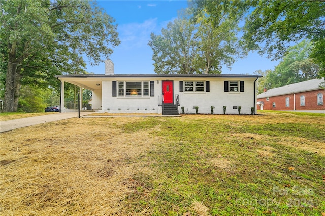 view of front of property with a front lawn and a carport