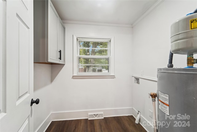 laundry room featuring water heater, crown molding, dark hardwood / wood-style flooring, and cabinets