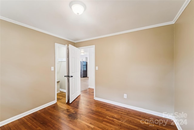 empty room with crown molding and dark hardwood / wood-style flooring