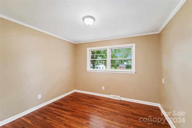 empty room with ornamental molding and hardwood / wood-style flooring