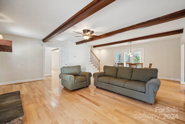 living room featuring beamed ceiling, ceiling fan, and light hardwood / wood-style flooring