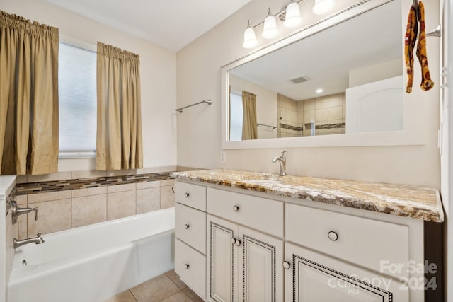 bathroom with a washtub, plenty of natural light, vanity, and tile patterned flooring