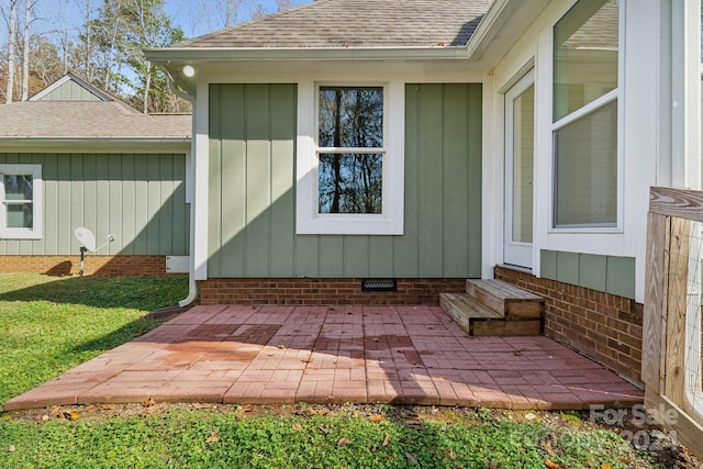 entrance to property featuring a yard and a patio