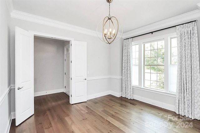 unfurnished room with a notable chandelier, dark hardwood / wood-style floors, and ornamental molding