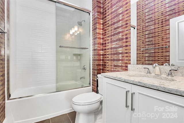 full bathroom featuring tile patterned floors, enclosed tub / shower combo, vanity, and toilet