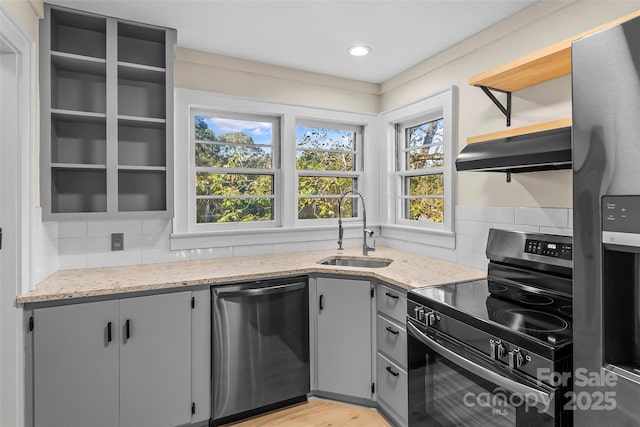 kitchen featuring sink, light stone countertops, stainless steel appliances, and tasteful backsplash