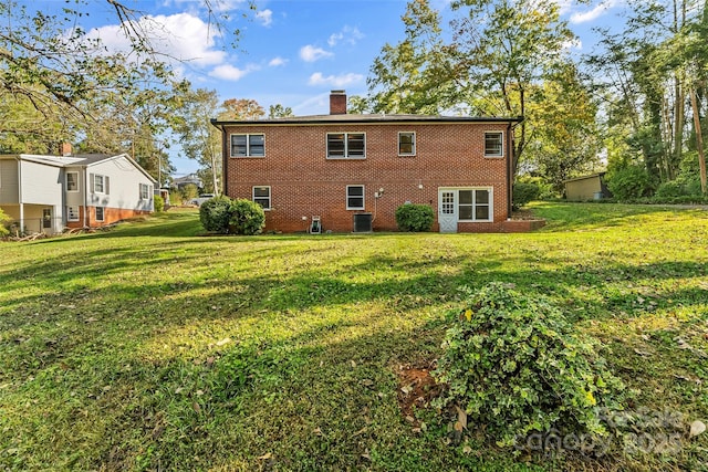 rear view of house with a yard and central AC unit