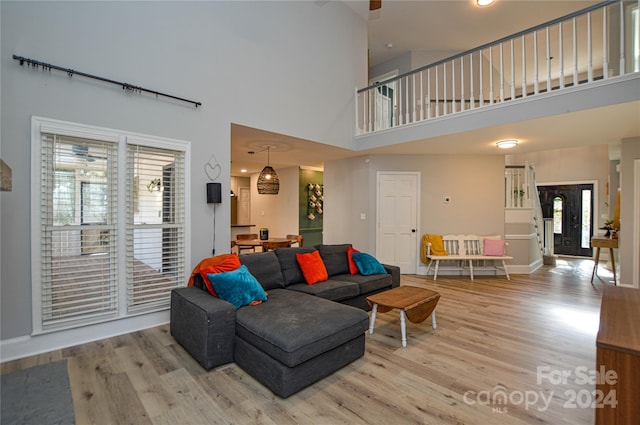 living room with a high ceiling and light hardwood / wood-style flooring