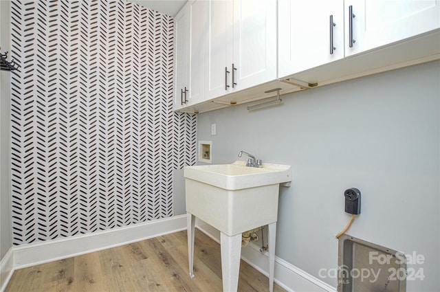 laundry area featuring cabinets and light hardwood / wood-style floors