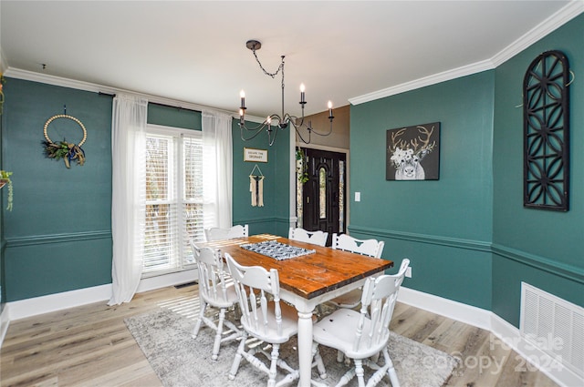 dining area featuring a chandelier, hardwood / wood-style floors, and crown molding