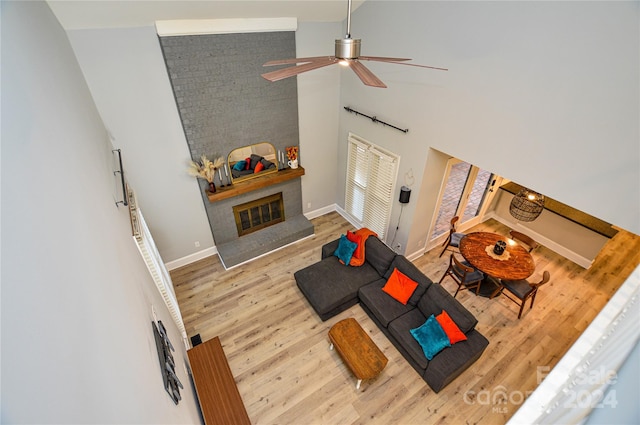 living room featuring ceiling fan, high vaulted ceiling, and light hardwood / wood-style floors