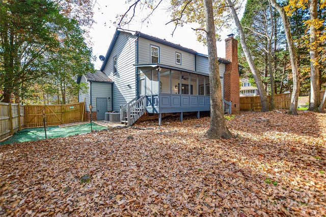 back of house with central air condition unit and a sunroom