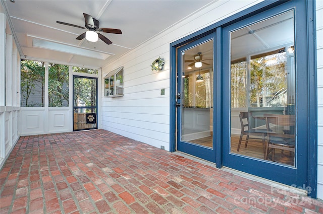 unfurnished sunroom featuring ceiling fan