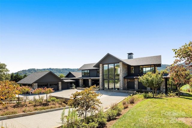 contemporary house with a front yard, a garage, and a mountain view