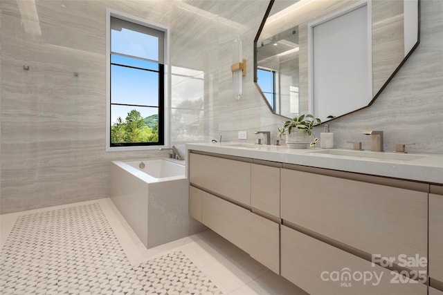 bathroom featuring tile walls, a tub, tile patterned floors, and vanity